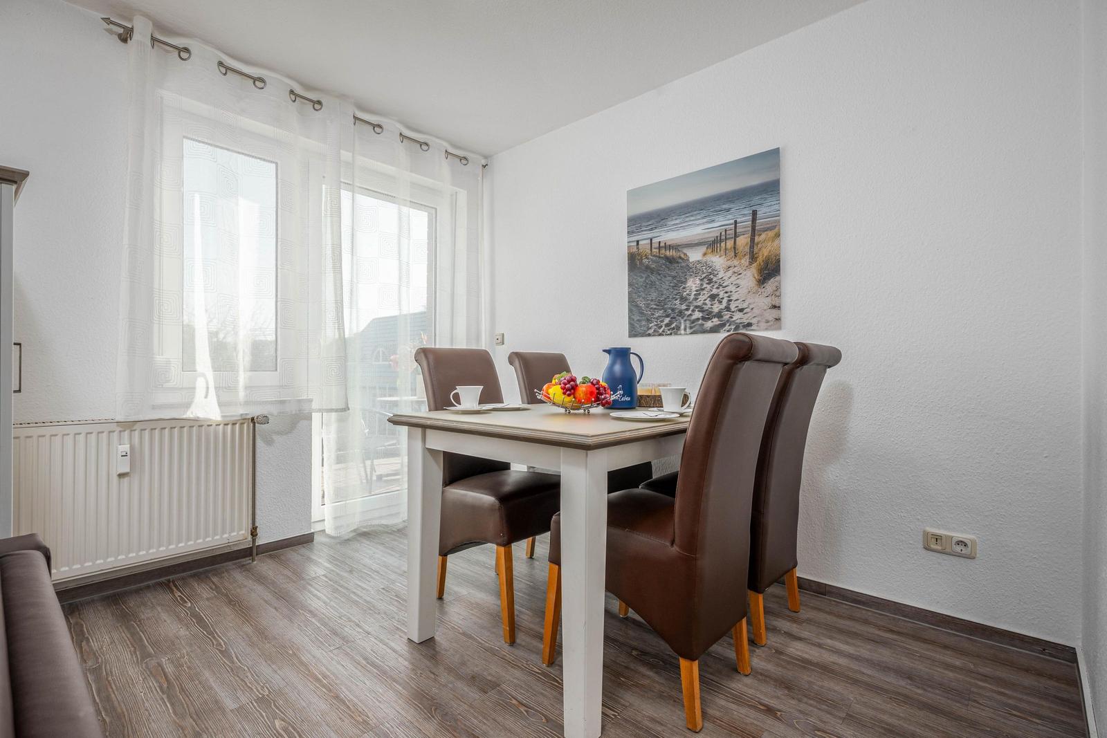 Esszimmer mit Tisch, Stühlen und Fenster zur Aussicht.