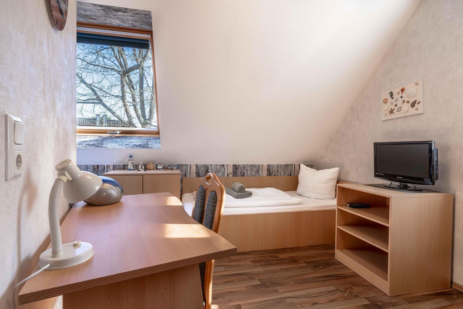 Schlafzimmer mit Einzelbett und TV