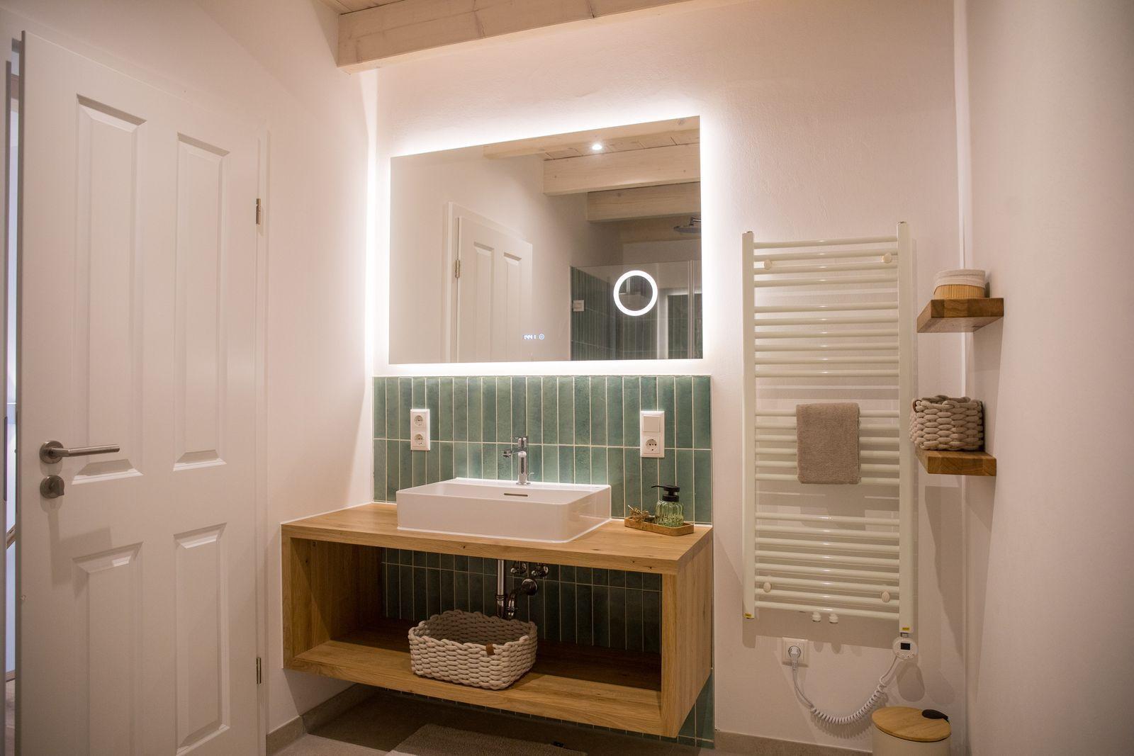 Badezimmer mit Waschtisch, Spiegel und Heizkörper