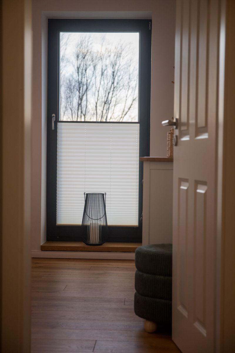 Eingangsbereich mit Fenster, Jalousie und Sitzbank.