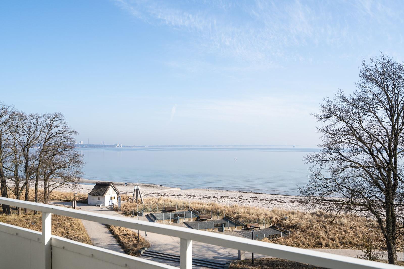 Blick auf Strand und See mit kleinem Haus und Bäumen