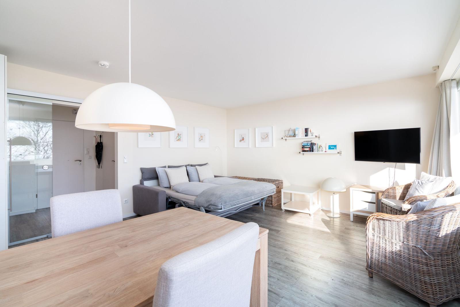 Wohn- und Essbereich mit Bett, TV und Esstisch