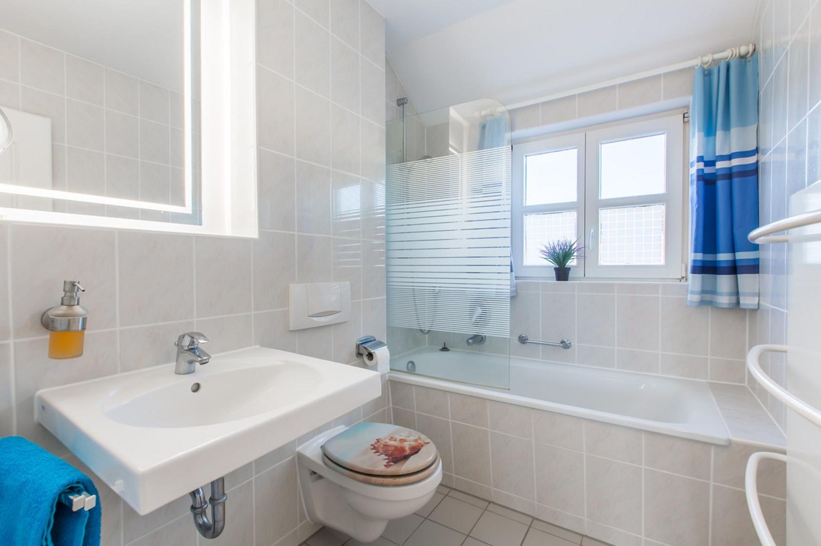 Badezimmer mit Badewanne, Dusche, Waschbecken und Toilette.