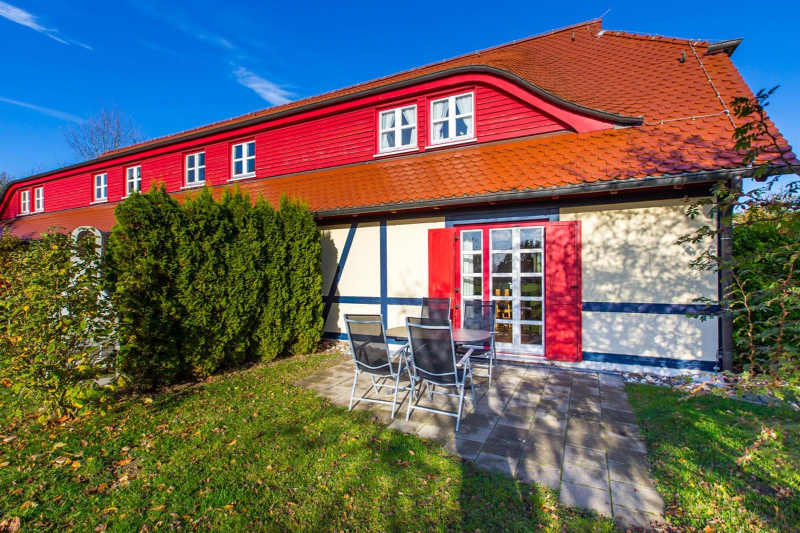 Rotes Fachwerkhaus mit Terrasse und Garten.