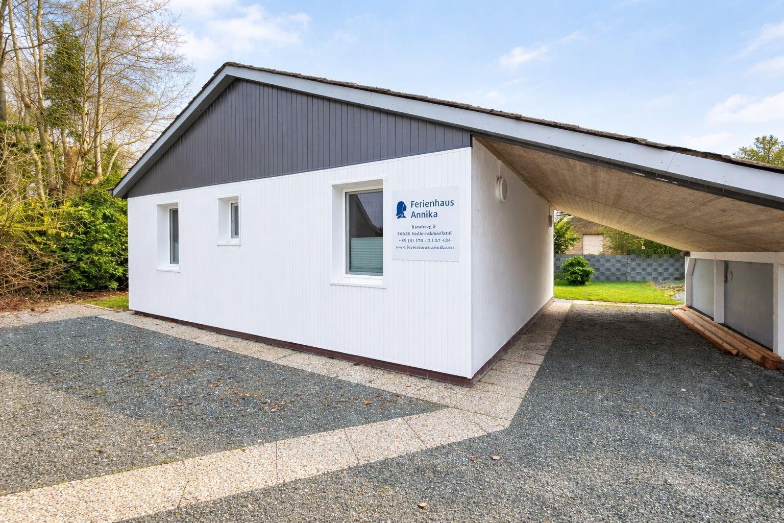 Ferienhaus Annika mit Garage und Gartenbereich. Modernes Gebäude mit weißen Wänden.