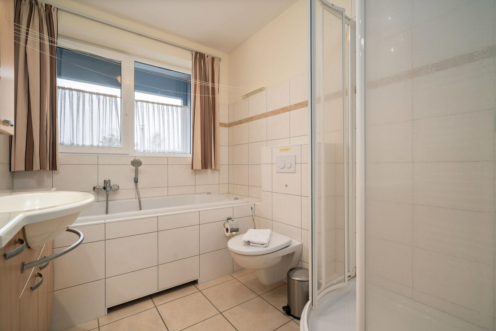 Badezimmer mit Badewanne, Dusche, Toilette und Waschbecken