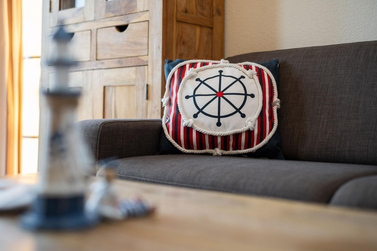 Ein Kissen mit Ruderhausmotiv auf einem Sofa.