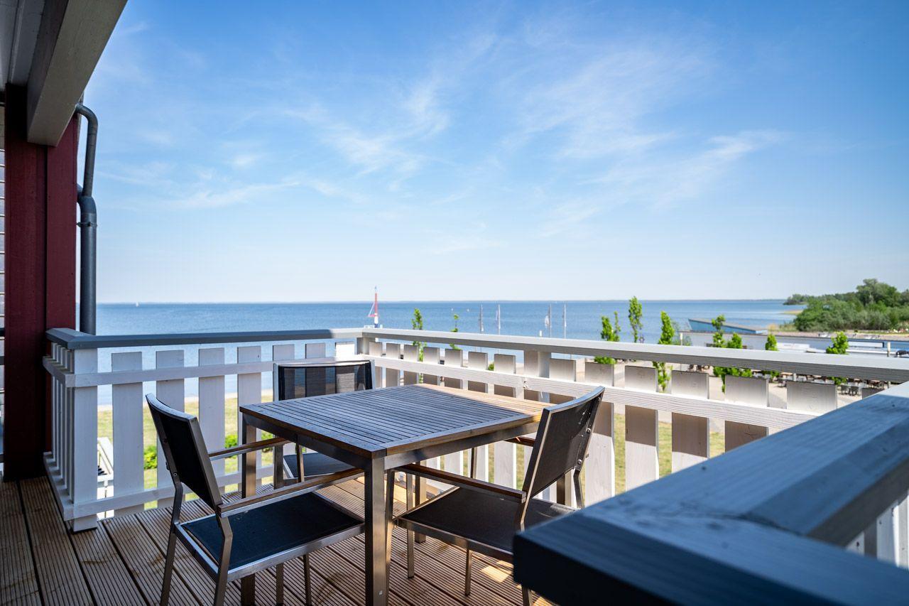 Terrasse mit Tisch und Stühlen bietet Meerblick.
