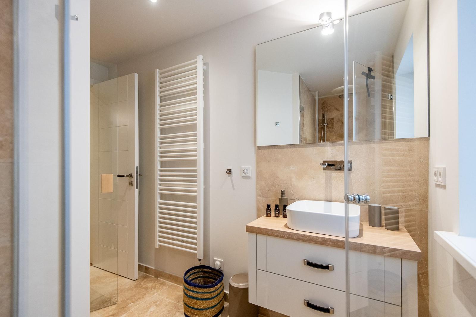 Badezimmer mit Waschtisch, Spiegel und Dusche