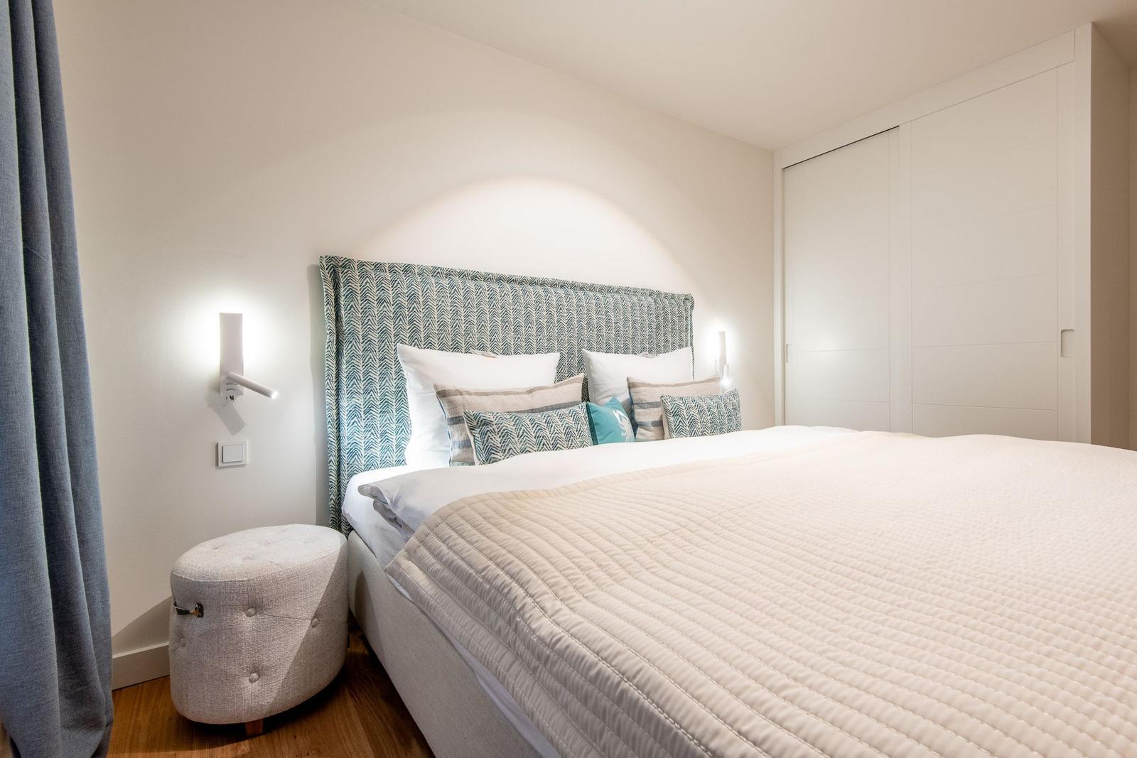 Schlafzimmer mit Bett, Nachttisch und Kleiderschrank.