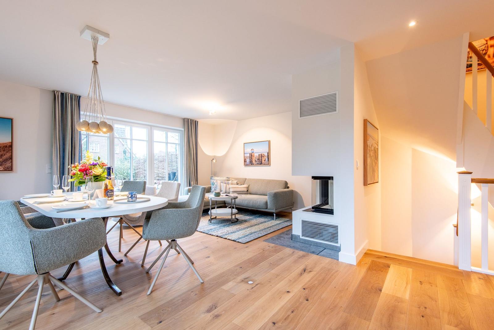 Wohn- und Essbereich mit Sofa, Esstisch und Kamin.