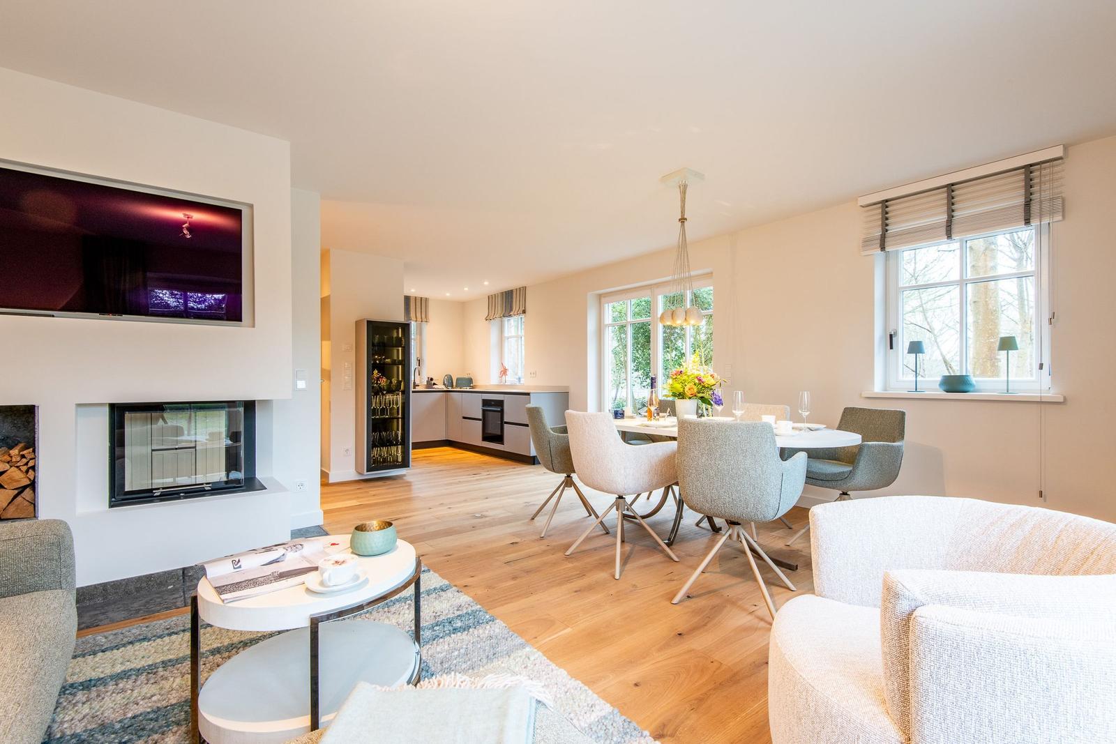 Wohn- und Essbereich mit Kamin, Esstisch und Küchenbereich.