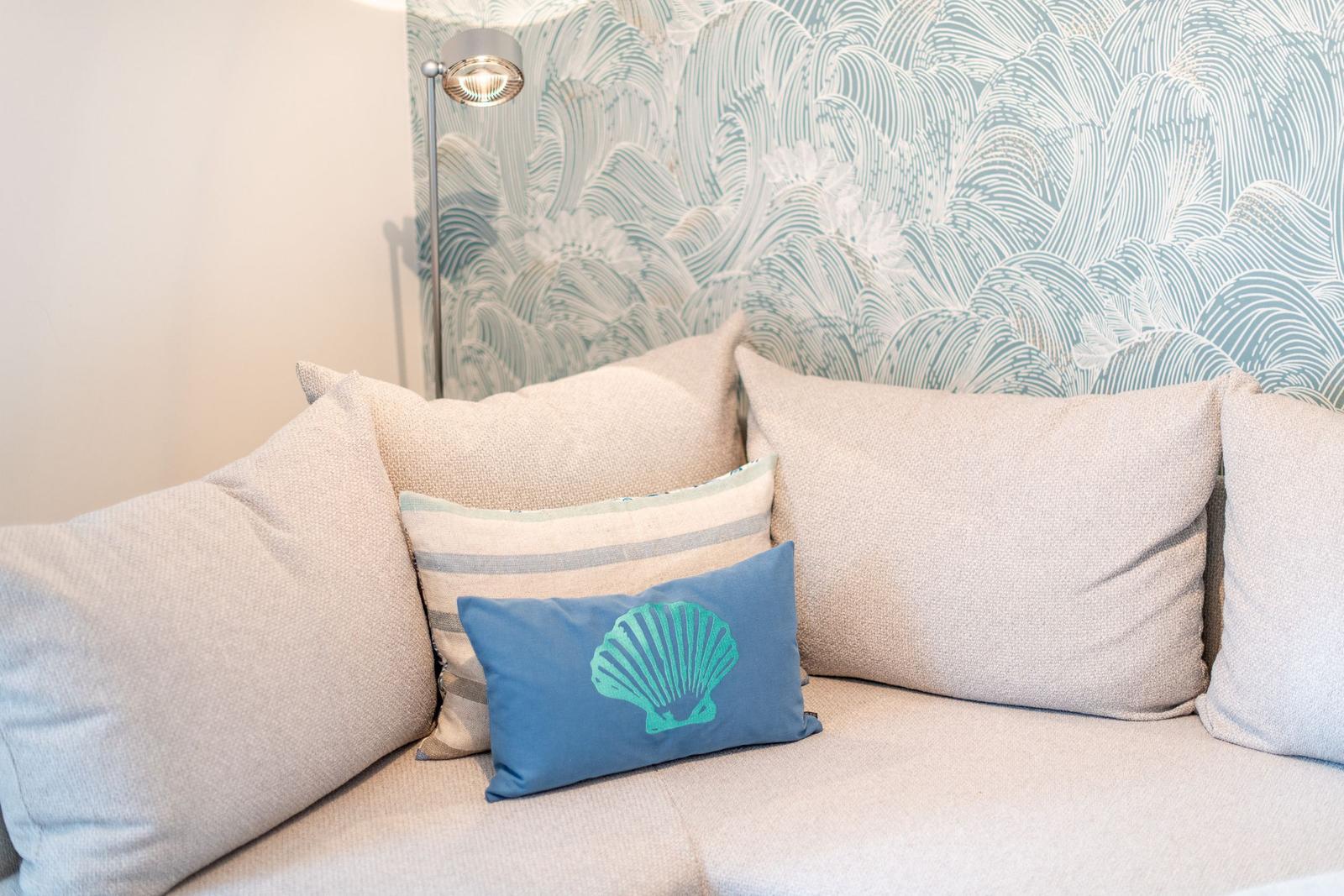 Sofa mit Kissen vor Wellenmuster-Wand
