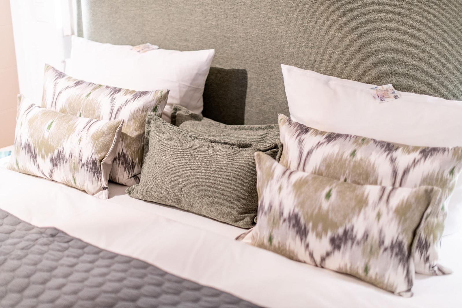Bettkopfteil mit Kissen in verschiedenen Mustern und Farben