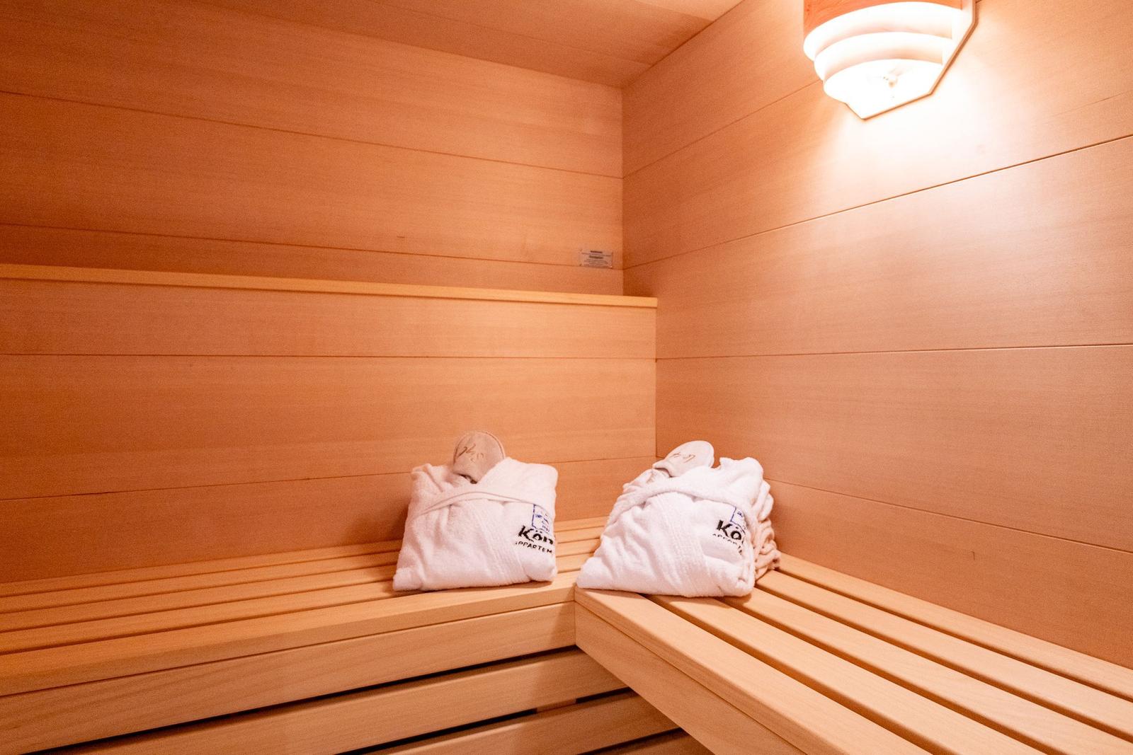 Sauna mit Holzbank und weißen Handtüchern