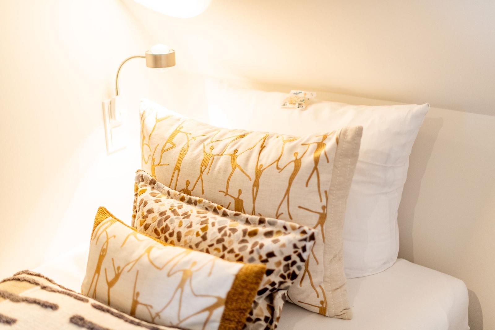 Bettkopf mit Kissen und Wandlampe