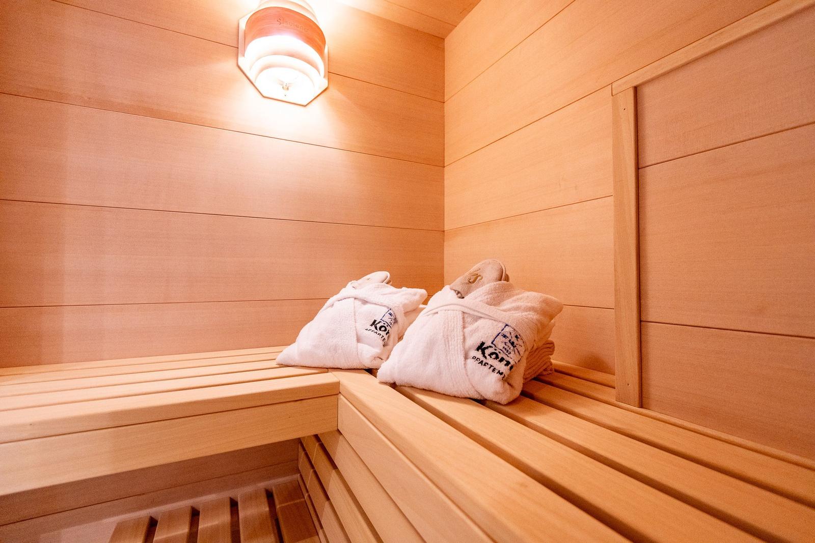 Sauna mit Holzbank und weißen Handtüchern