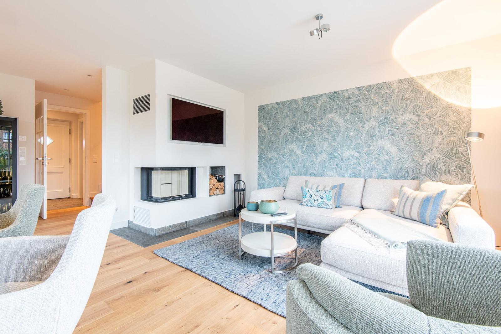 Wohnzimmer mit Sofa, Kamin und Wellenwandtapete.