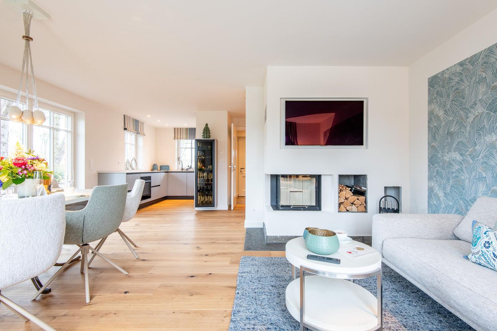 Wohn- und Essbereich mit Kamin, Sofa und Esstisch.