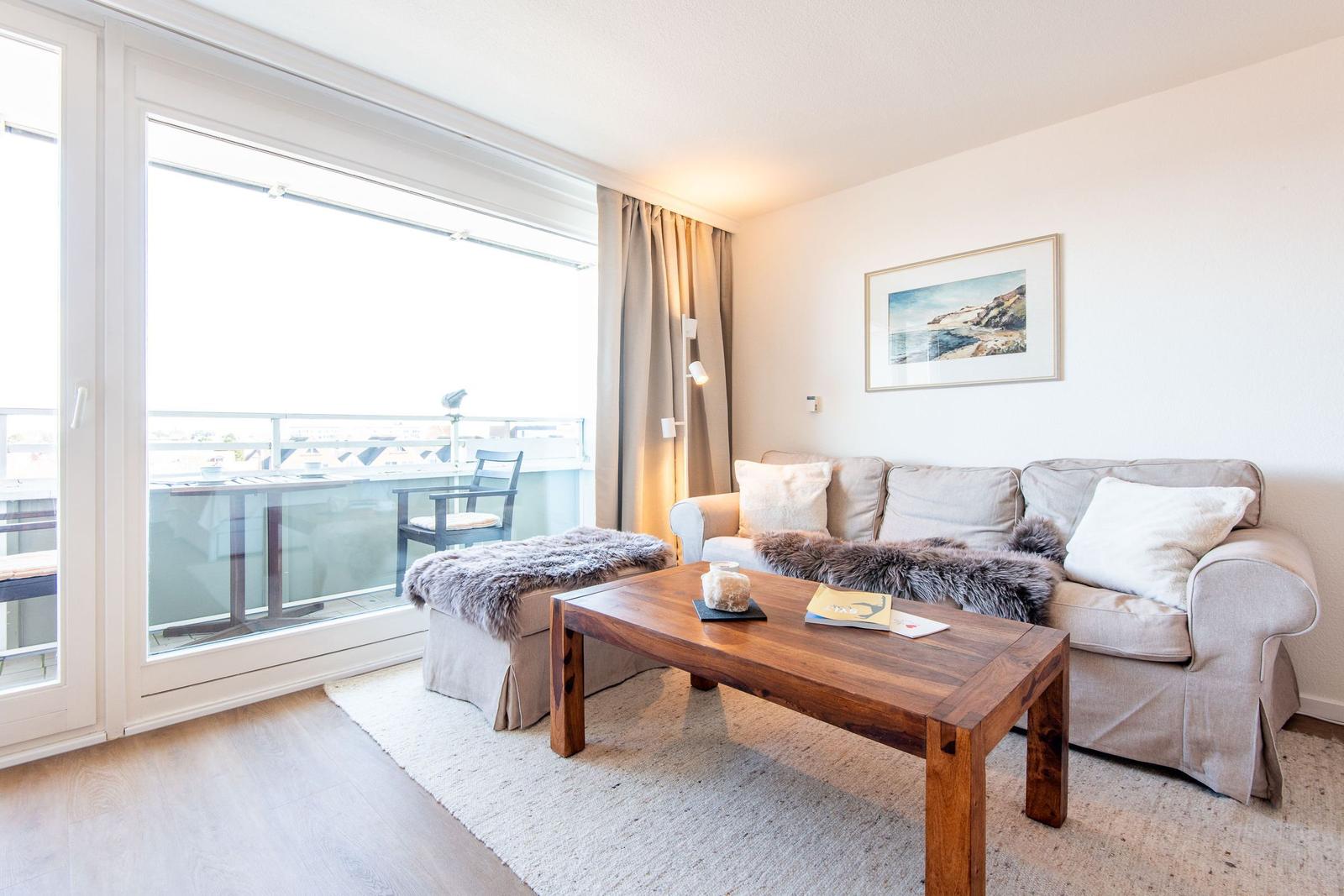 Wohnzimmer mit Sofa, Couchtisch und Balkonansicht.