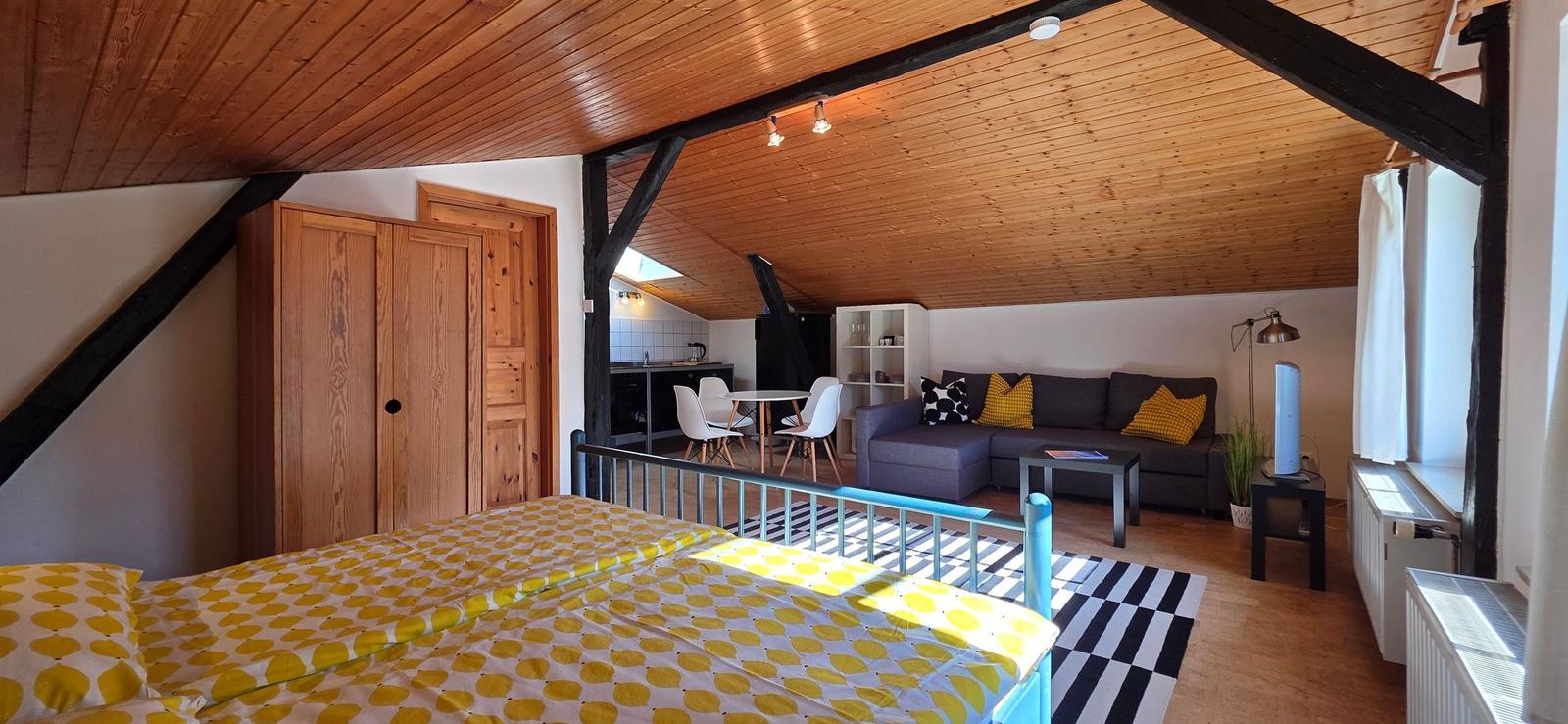Schlafzimmer mit Blick auf Wohnbereich und Küche