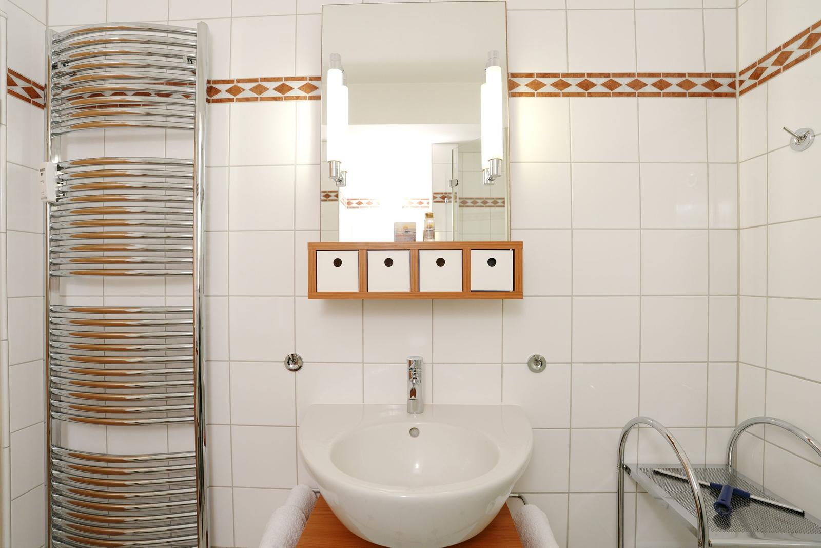 Bathroom with sink, mirror, and heated towel rack