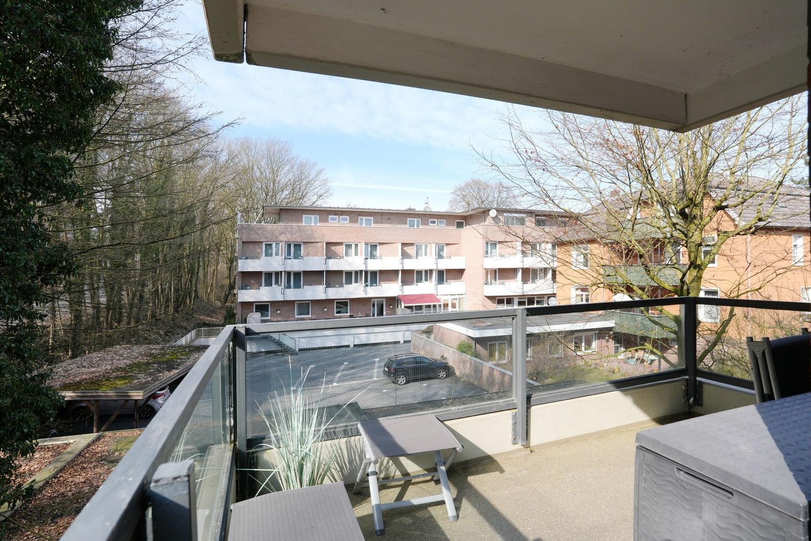 Terrace with seating and view of apartment buildings and trees.