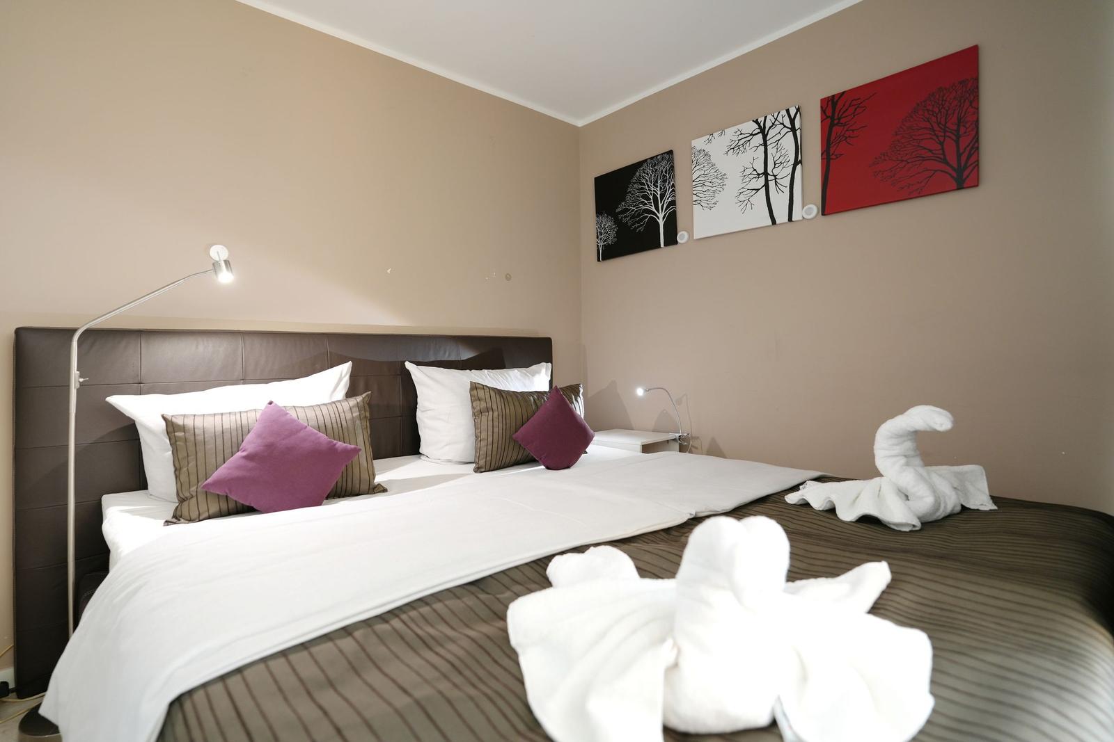 Bedroom with bed, pillows, and wall art