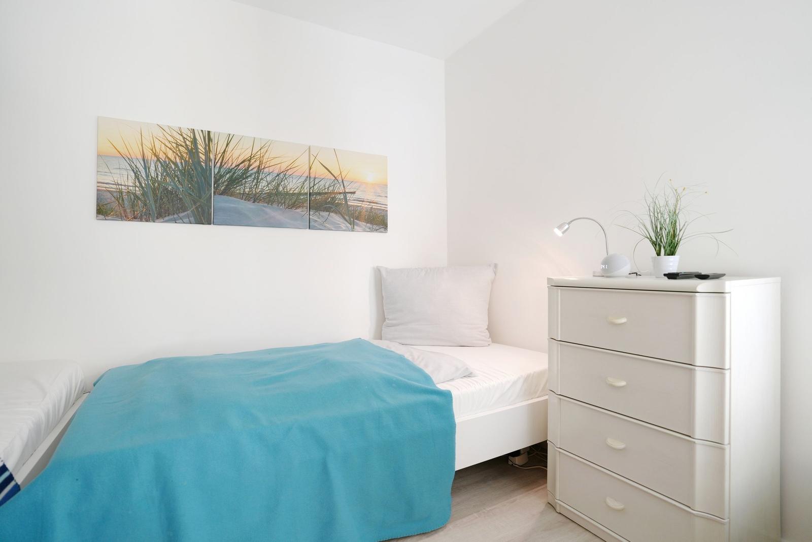 Bedroom with bed, dresser, and wall art