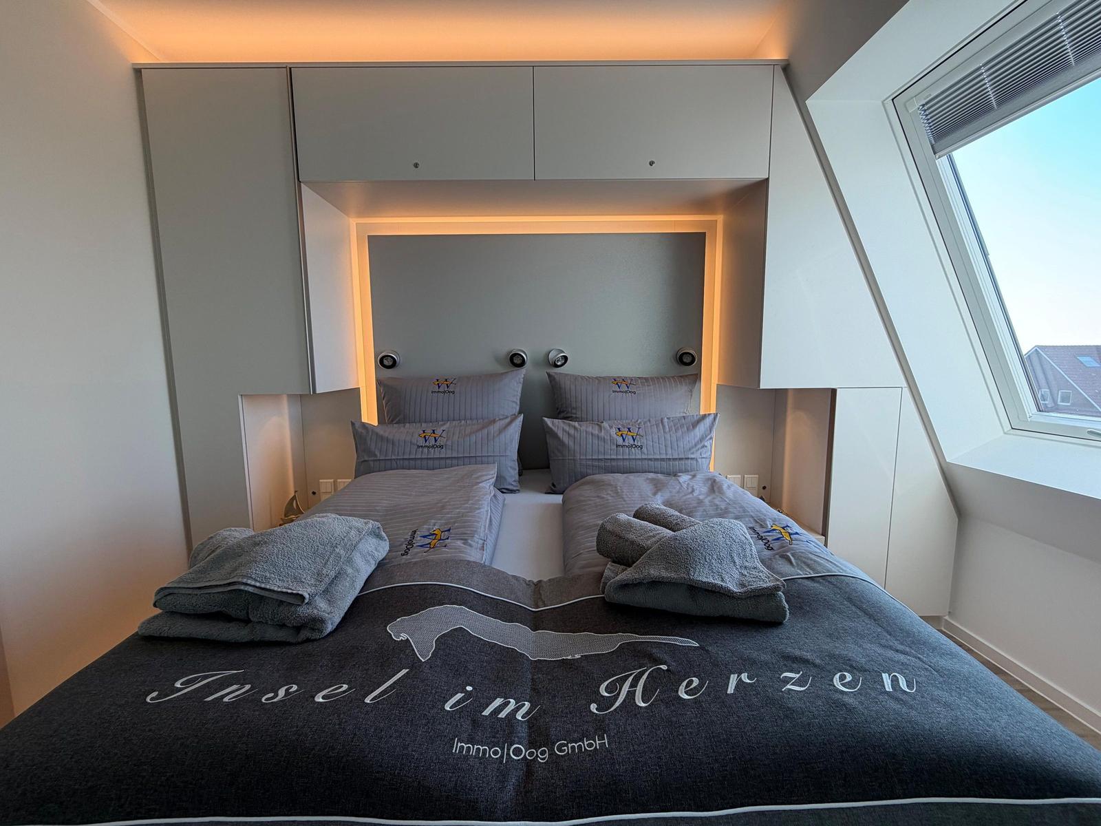 Schlafzimmer mit Doppelbett, eingebauter Schrank und Dachfenster.