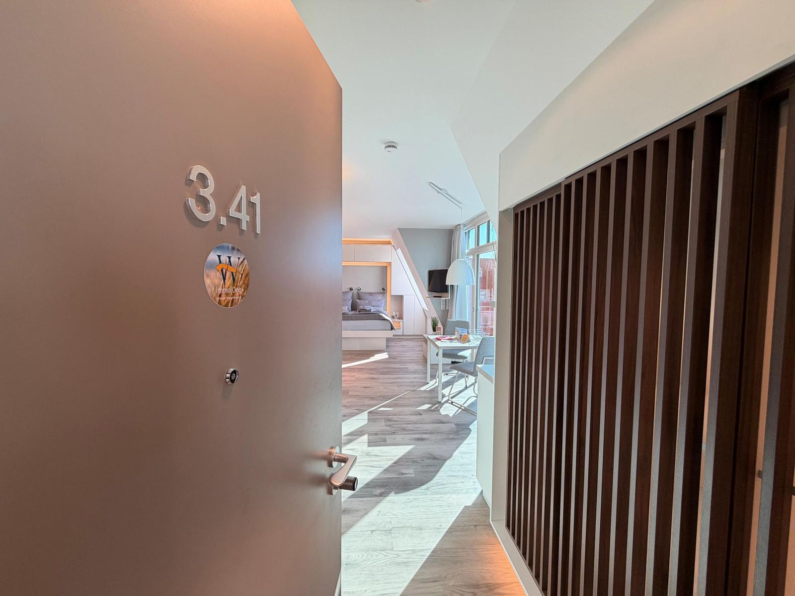 Eingangsbereich mit Tür zur Wohnung 3.41 und Blick in das Schlafzimmer.