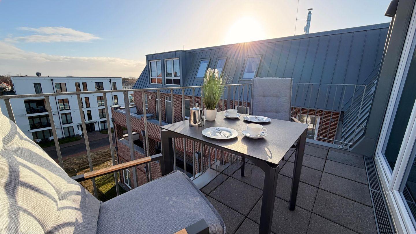 Terrasse mit Tisch, Stühlen und Blick auf Gebäude