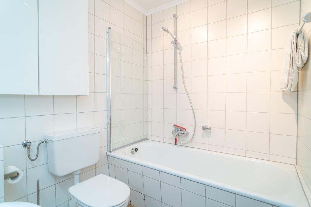 Badezimmer mit Badewanne, Duschbrause und Toilette.