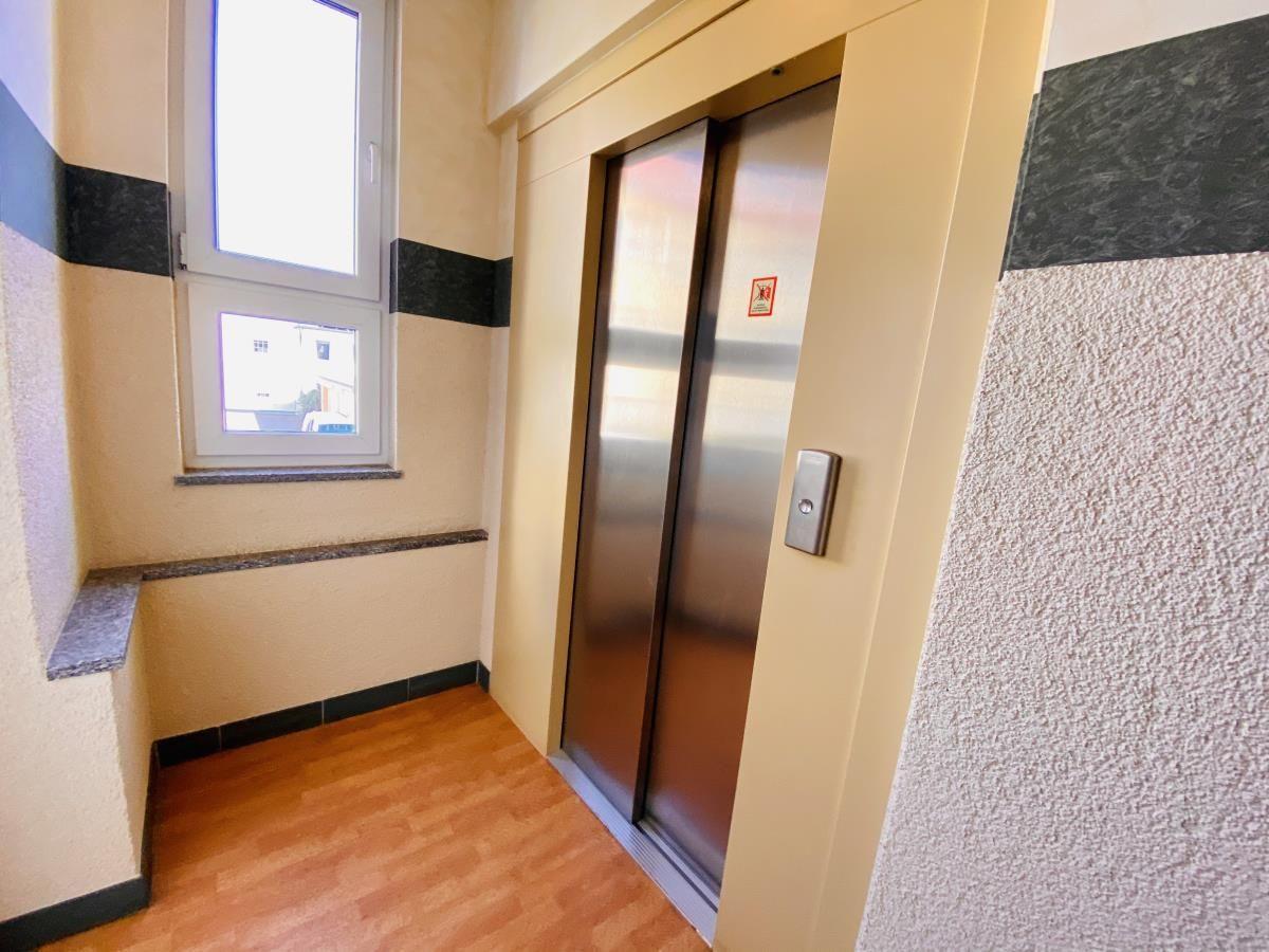 Aufnahme der Aufzugsnische mit Fenster und Holzboden