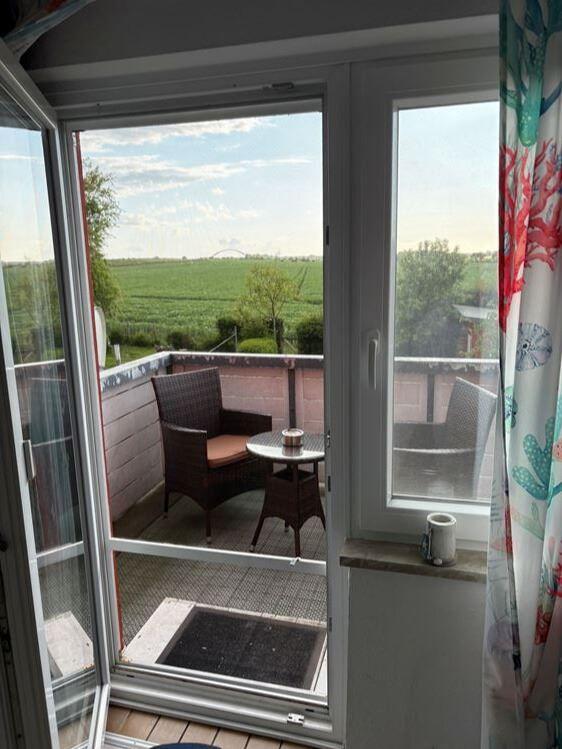 Terrasse mit Sitzgelegenheit und Blick auf grüne Landschaft.