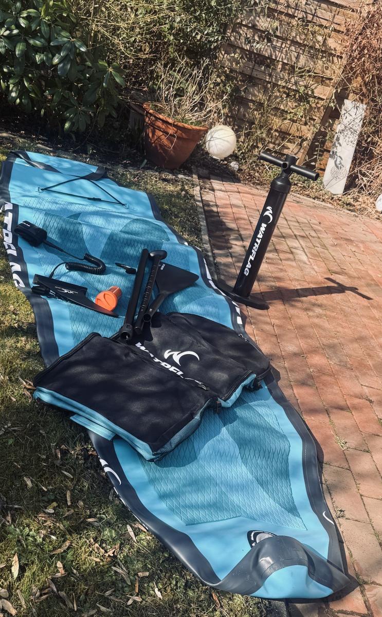 Aufstellplatz für Stand-Up-Paddleboard mit Pumpe und Zubehör im Garten.