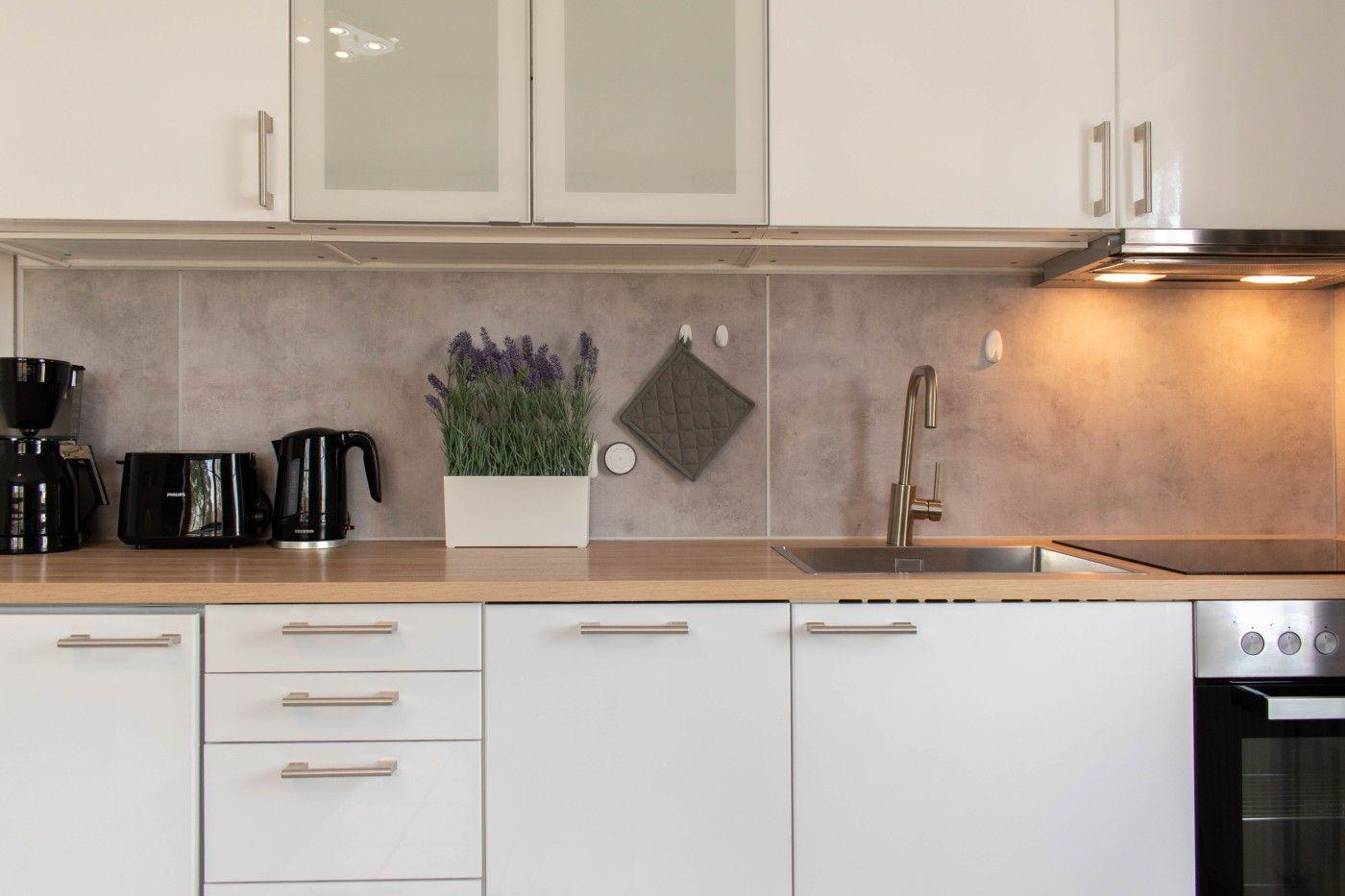 Küche mit weißen Schränken, Holz Arbeitsplatte und Lavendel Pflanze.