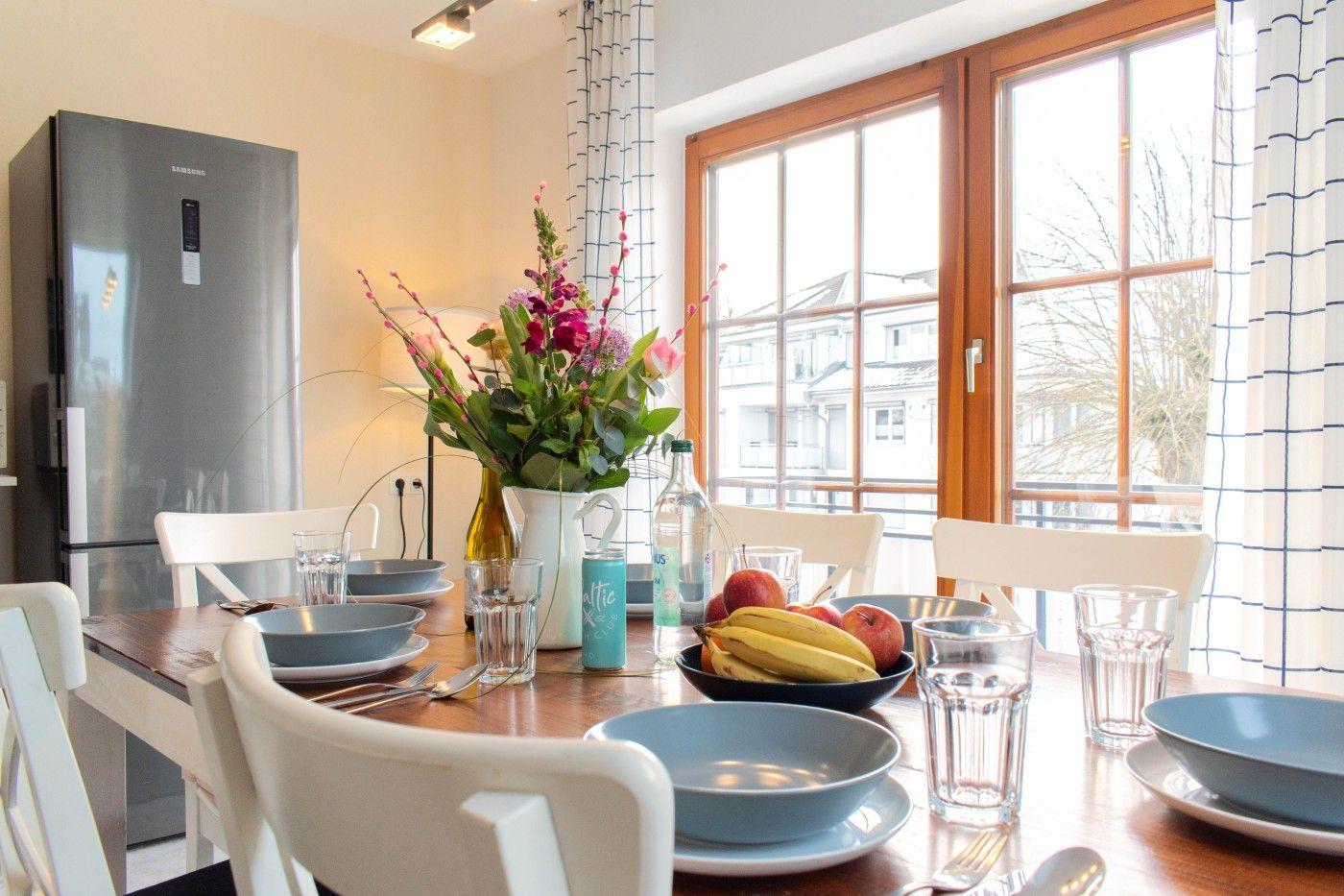 Essbereich mit Tisch, Stühlen und Blick auf Balkon.