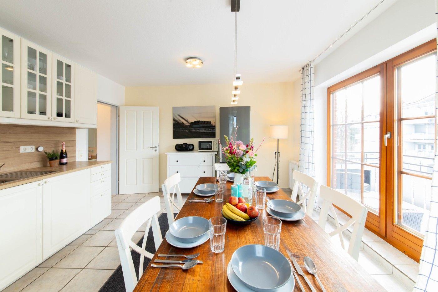 Essbereich mit Holztisch, Stühlen und Fenster zur Terrasse