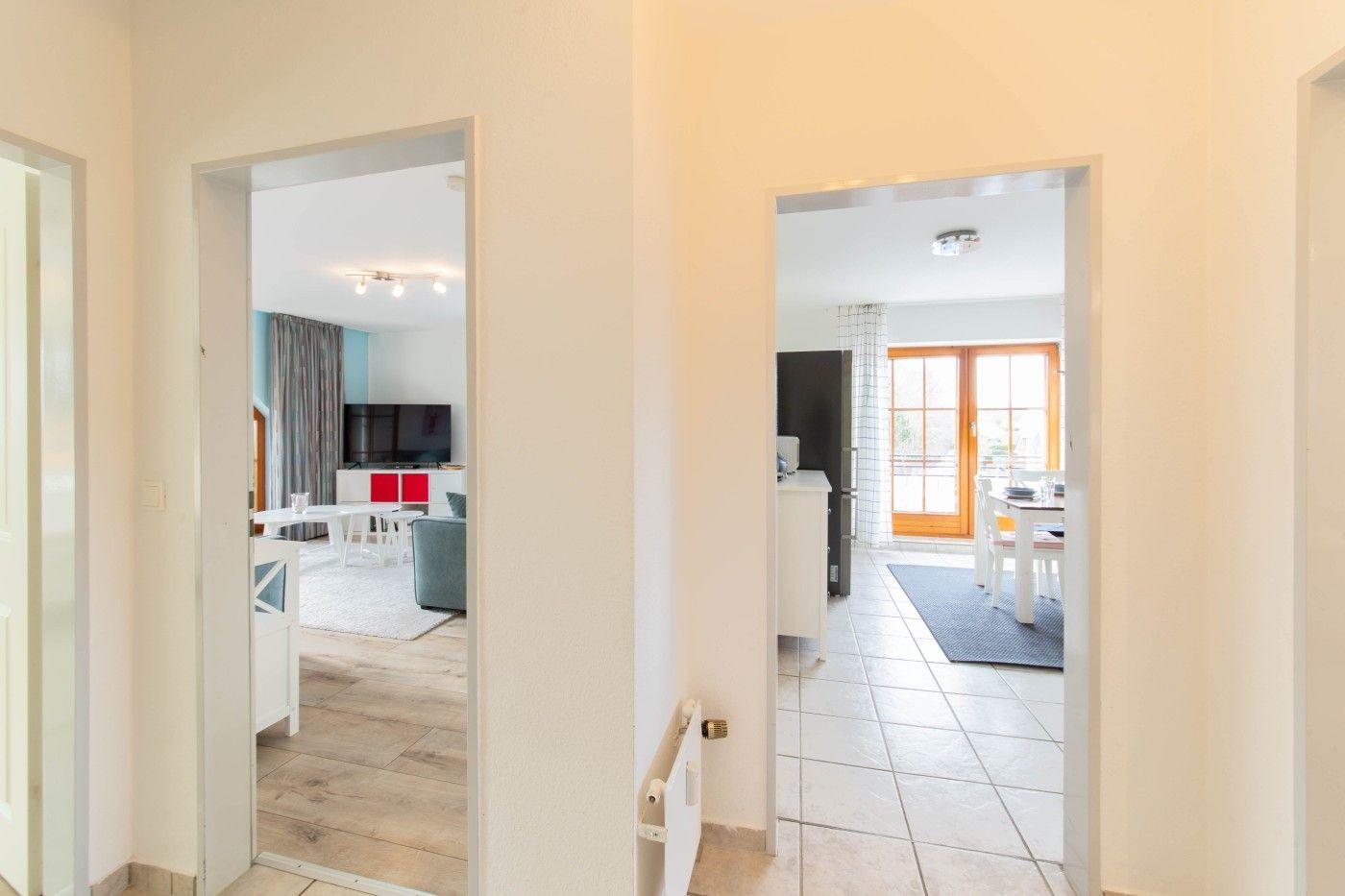 Haus mit Blick in Wohn- und Essbereich mit Küchenzeile und Terrassentür.