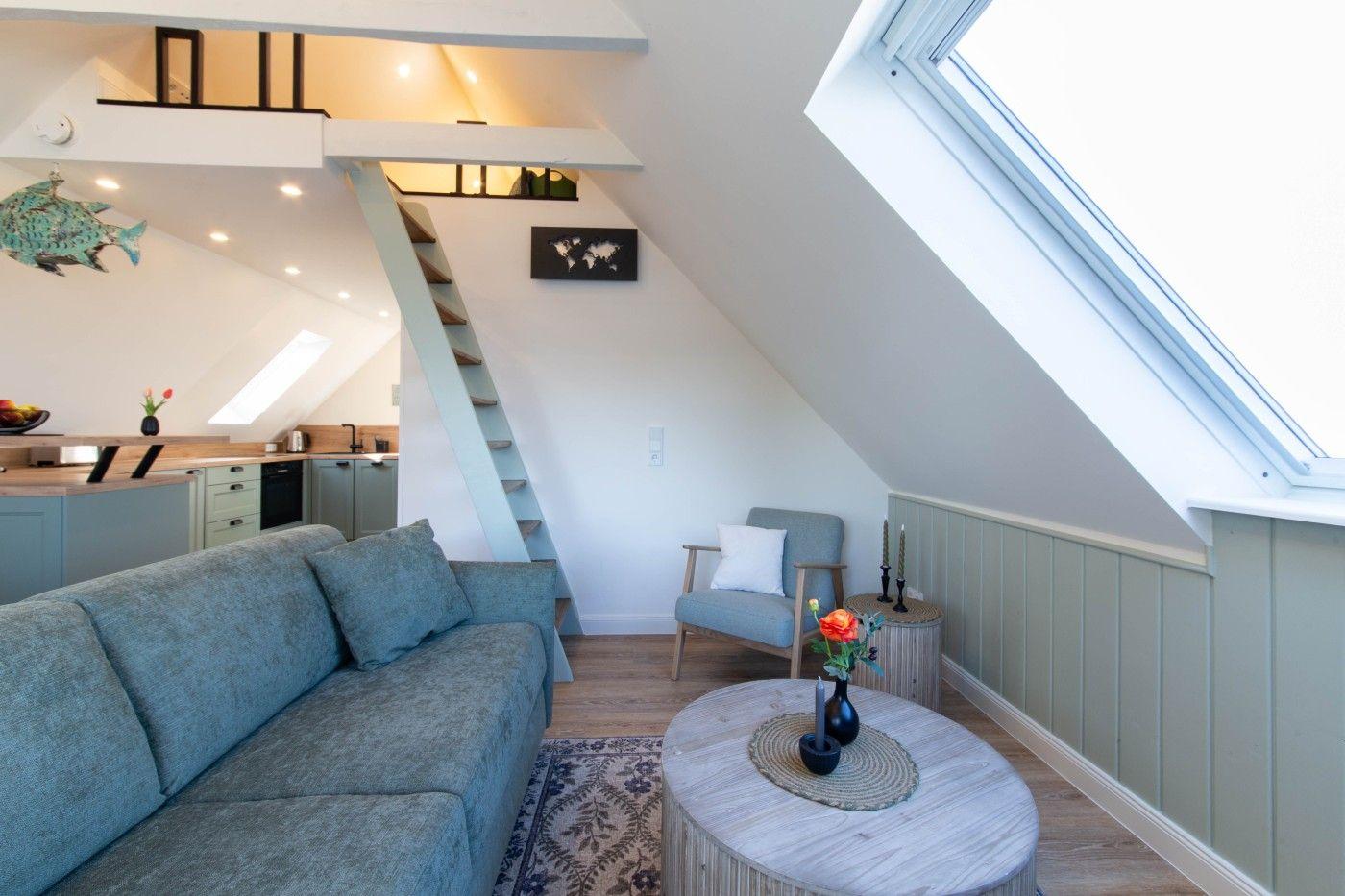 Wohnbereich mit Sofa, Couchtisch und Treppe zur oberen Etage.