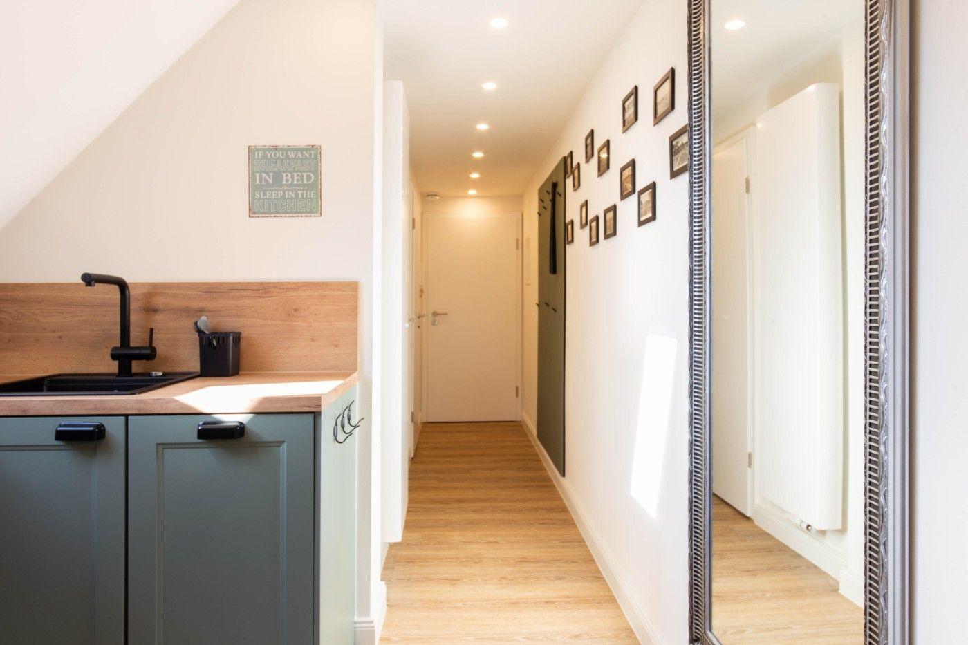 Küche mit Holzoberfläche und Korridor mit Wanddekoration.