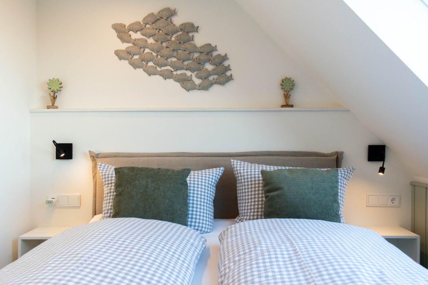 Schlafzimmer mit Doppelbett, Wanddekoration und Nachttischen.