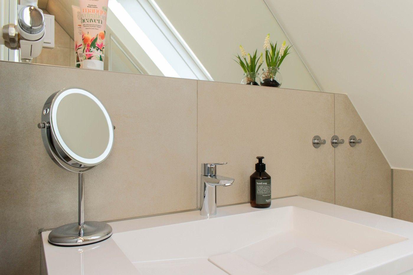 Badezimmer mit Waschbecken, Spiegel und Handseife