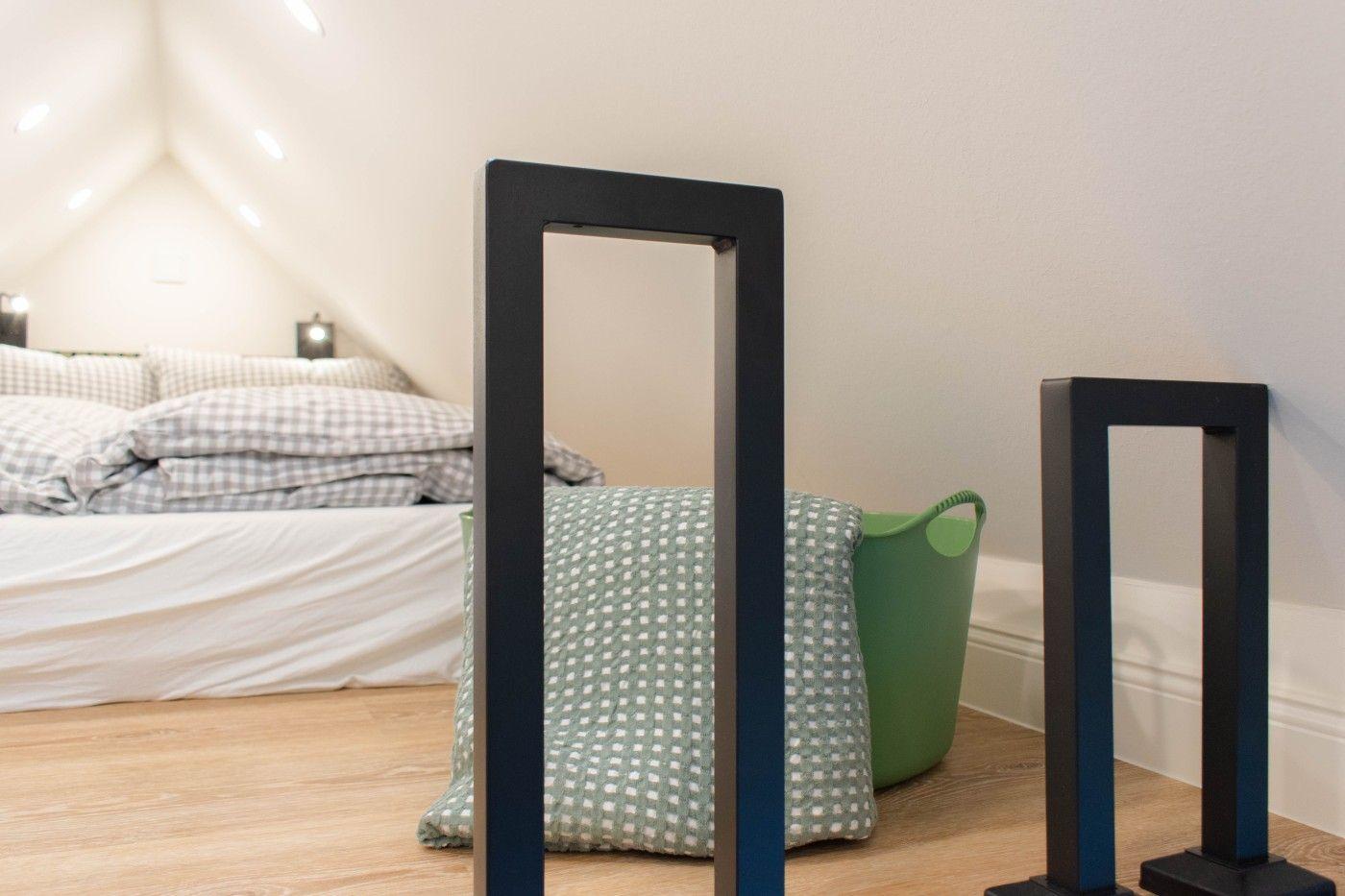 Schlafzimmer mit Bett, Spiegeln und grünem Korb.