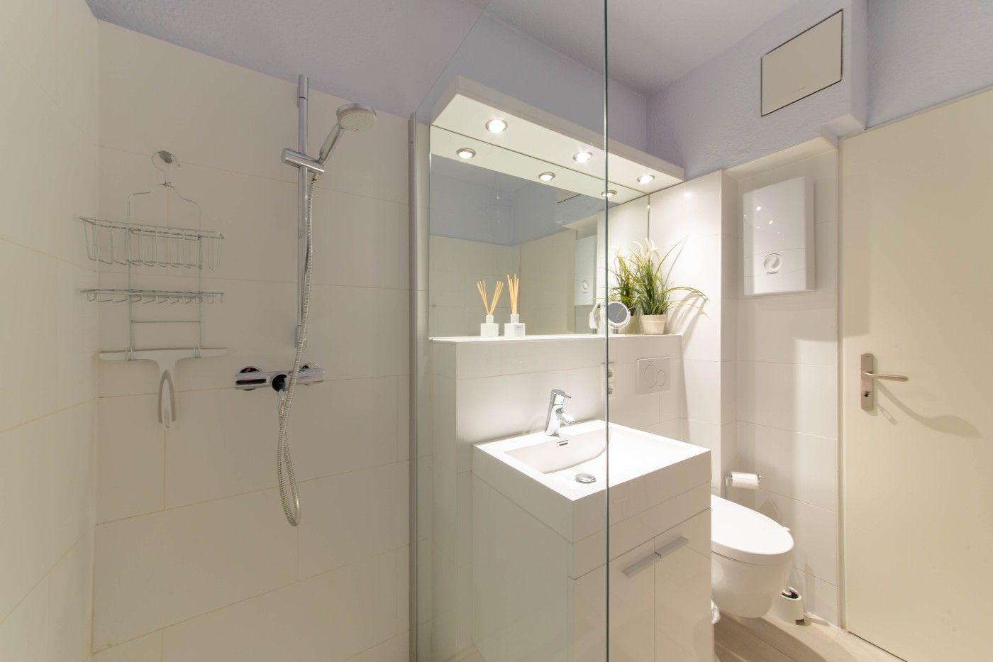 Badezimmer mit Dusche, Waschbecken und Toilette