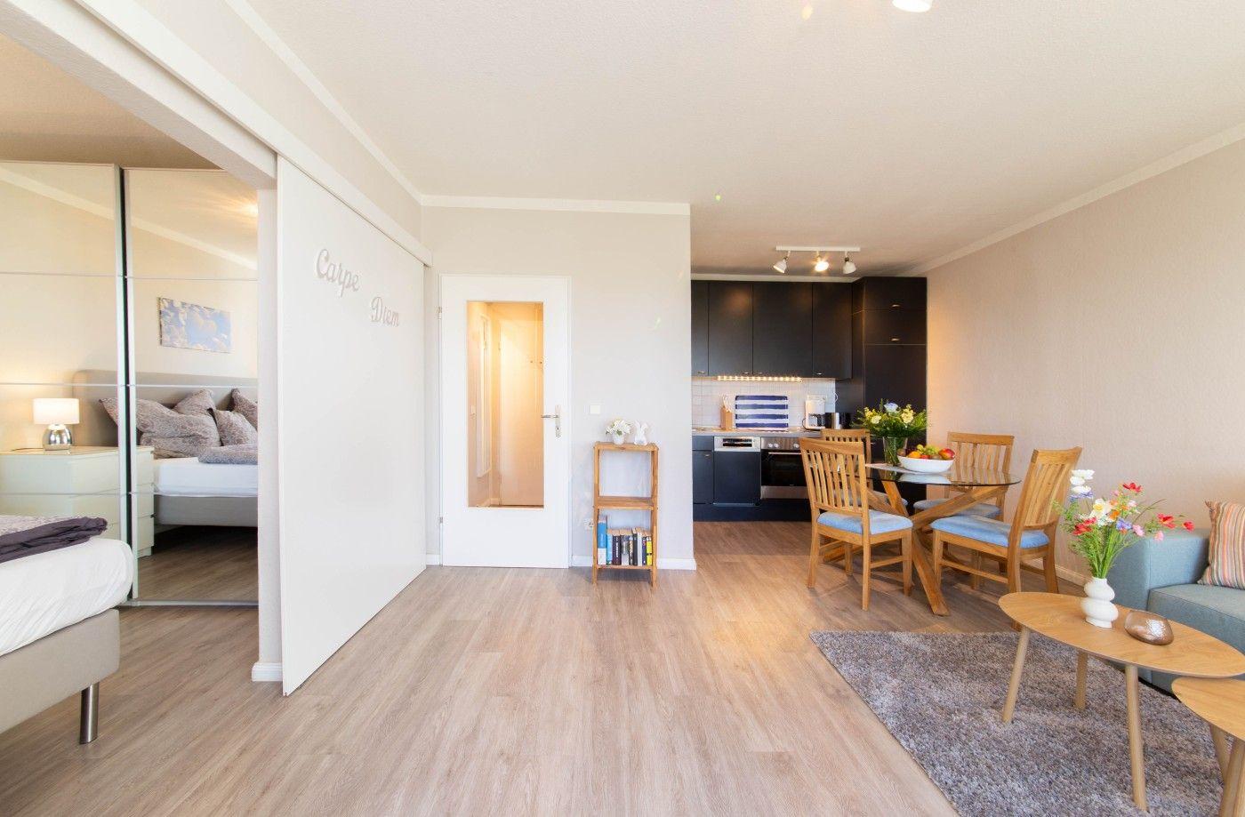 Wohnung mit Schlafzimmer, Küche und Essbereich. Holzboden und moderne Einrichtung.