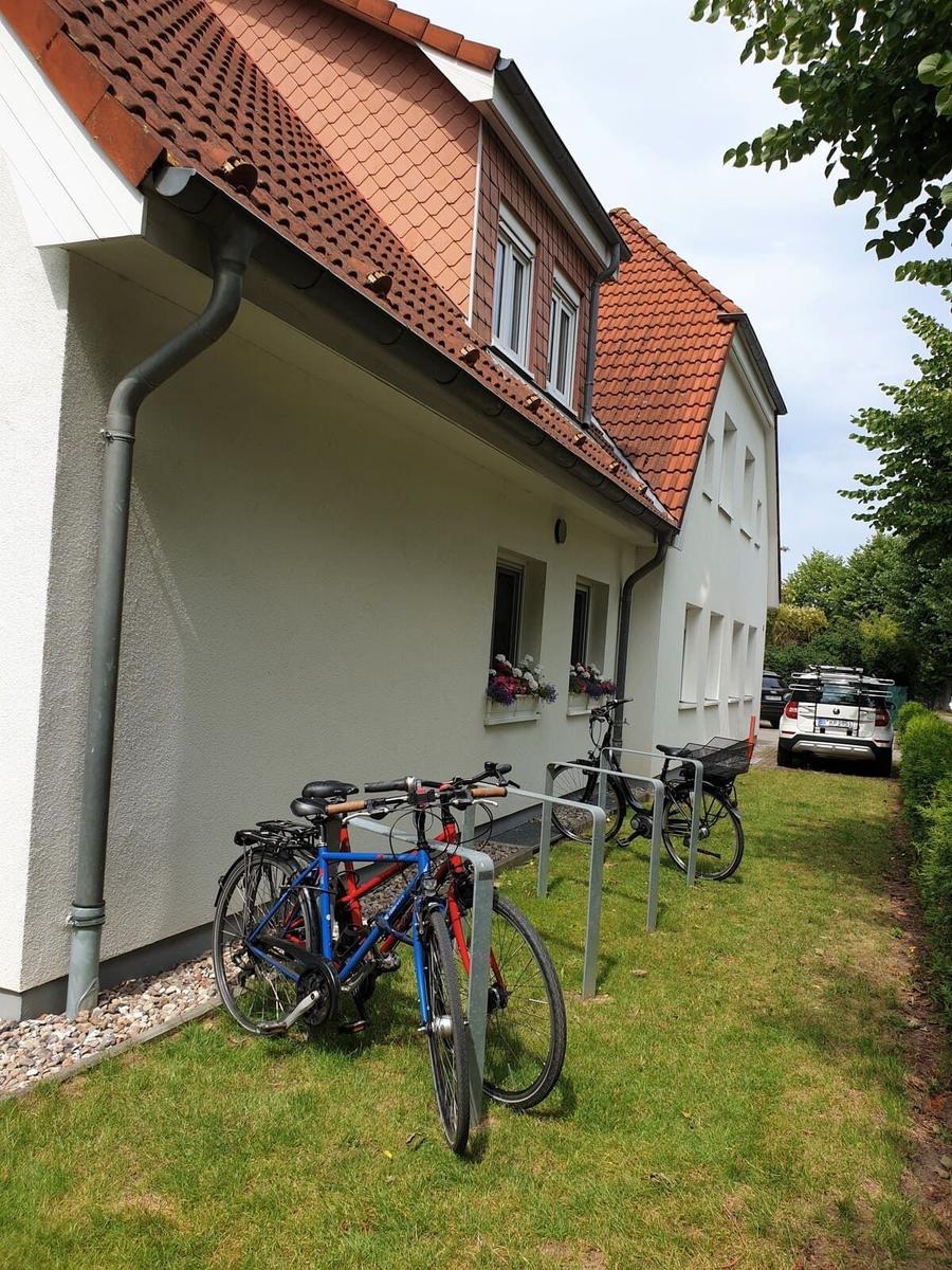 Haus mit rotem Dach, Fahrräder und Grünfläche vorne