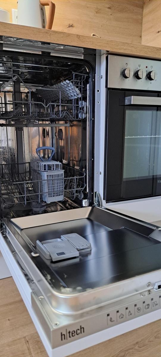 Ein h|tech Spülmaschine mit offener Tür und sichtbaren Körben.