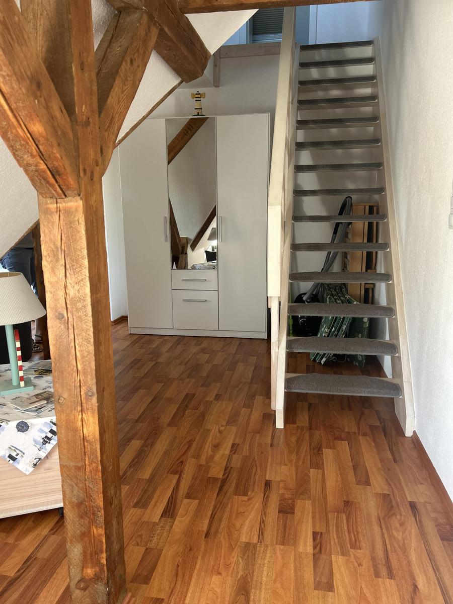 Haus mit Holzfußboden, Treppe und Kleiderschrank unter Dachschrägen.